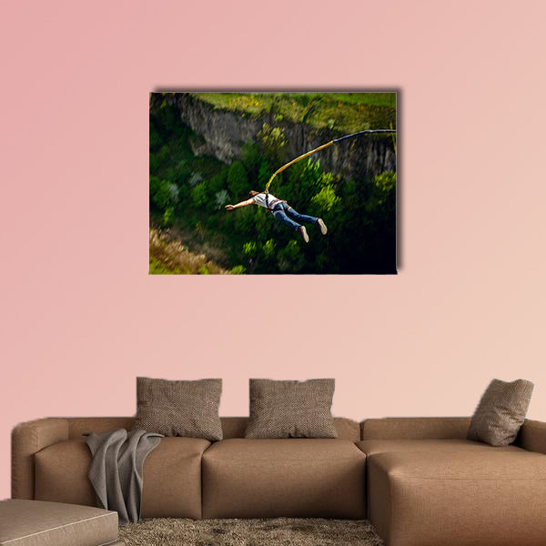 An extreme sportsman jumps on a rope from a great height Multi panel canvas wall art