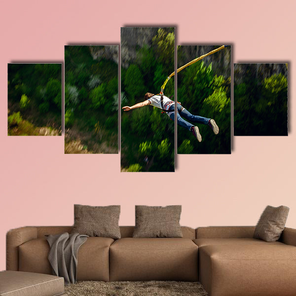 An extreme sportsman jumps on a rope from a great height Multi panel canvas wall art
