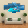 Landscape with white passenger airplane, sky, islands and blue water Multi panel canvas wall art