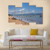 Unknown people collect fish from fishing nets at the beach with fishing boats Multi panel canvas wall art