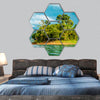 Small island with tropical trees on a lake with mountains hexagonal canvas wall art