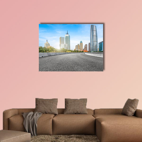 The empty asphalt road is built along modern commercial building wall art