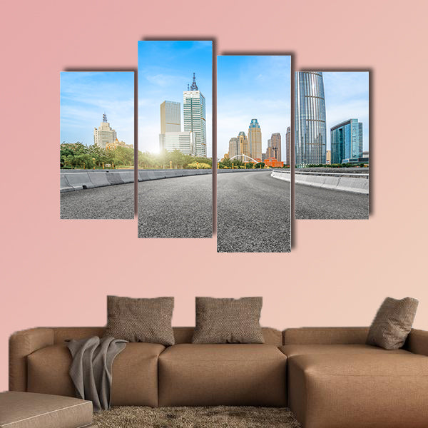The empty asphalt road is built along modern commercial building wall art