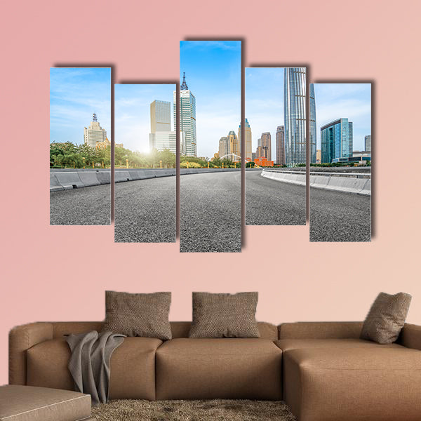 The empty asphalt road is built along modern commercial building wall art