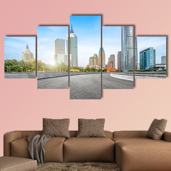 The empty asphalt road is built along modern commercial building wall art