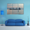 A ship with striped dolphin jumping outside the sea at sunset multi panel canvas wall art