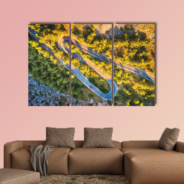 Aerial view of mountain curve road with cars, green forest at sunset wall art