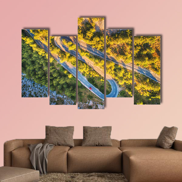Aerial view of mountain curve road with cars, green forest at sunset wall art