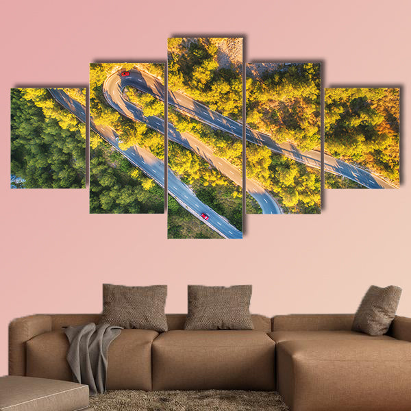 Aerial view of mountain curve road with cars, green forest at sunset wall art