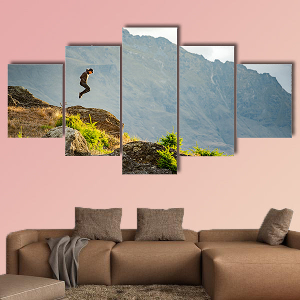 Young man jumping on Queenstown hill multi panel canvas wall art