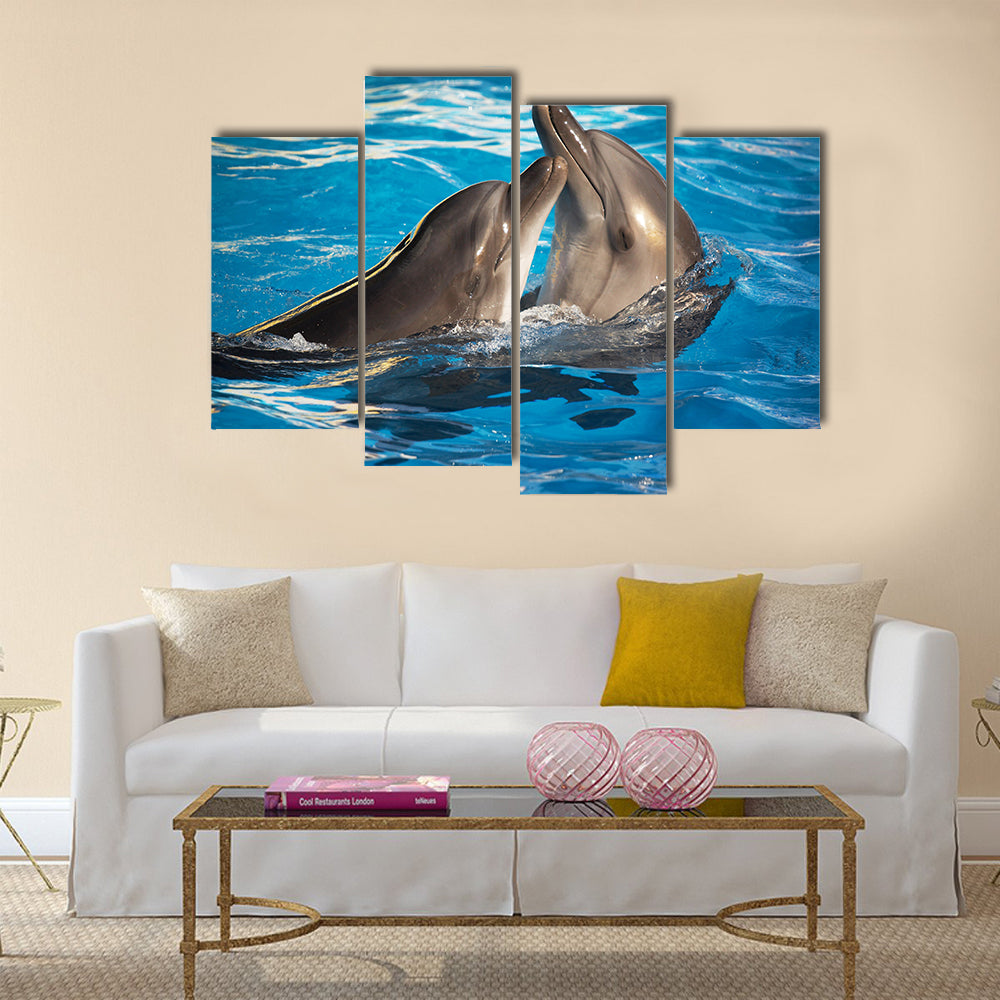 Pair of dolphins dancing in light-blue water Multi Panel Canvas Wall Art