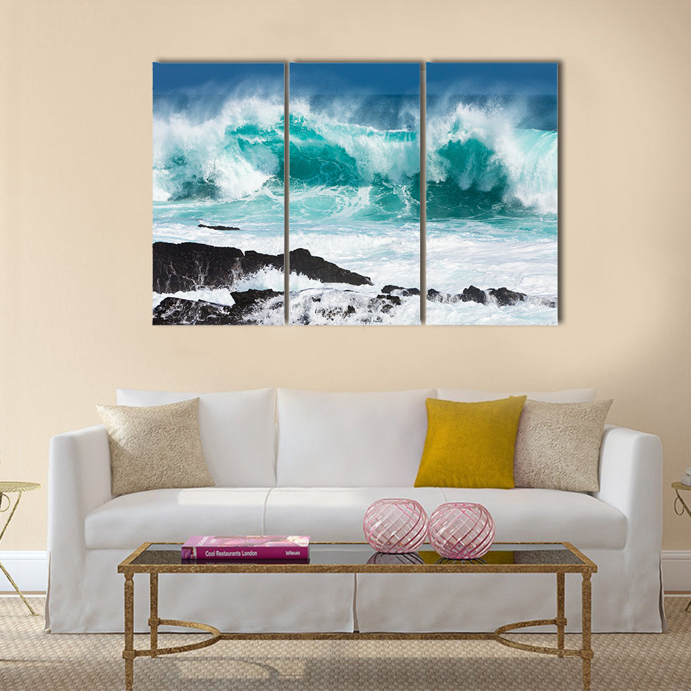 Turquoise rolling wave slaming on the rocks of the coastline Multi Panel Canvas Wall Art