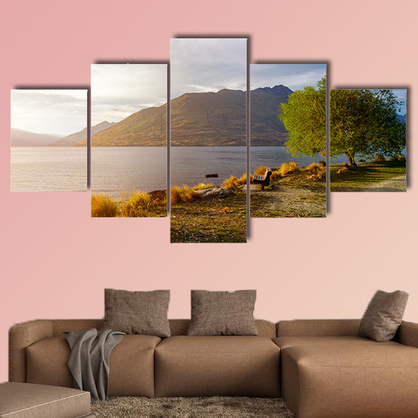 Wooden bench under tree on glowing sunset at Lake Wakatipu wall art