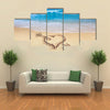 Heart with arrow, as love sign, drawn on the beach shore multi panel canvas wall art