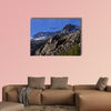 Bald eagle soaring over rocky peaks with a bright blue sky canvas wall art