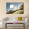 Golf ball flying over green field Multi Panel Canvas Wall Art