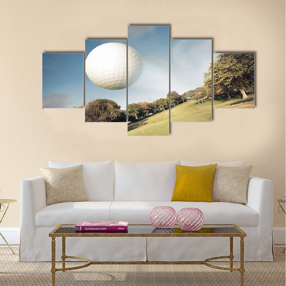 Golf ball flying over green field Multi Panel Canvas Wall Art