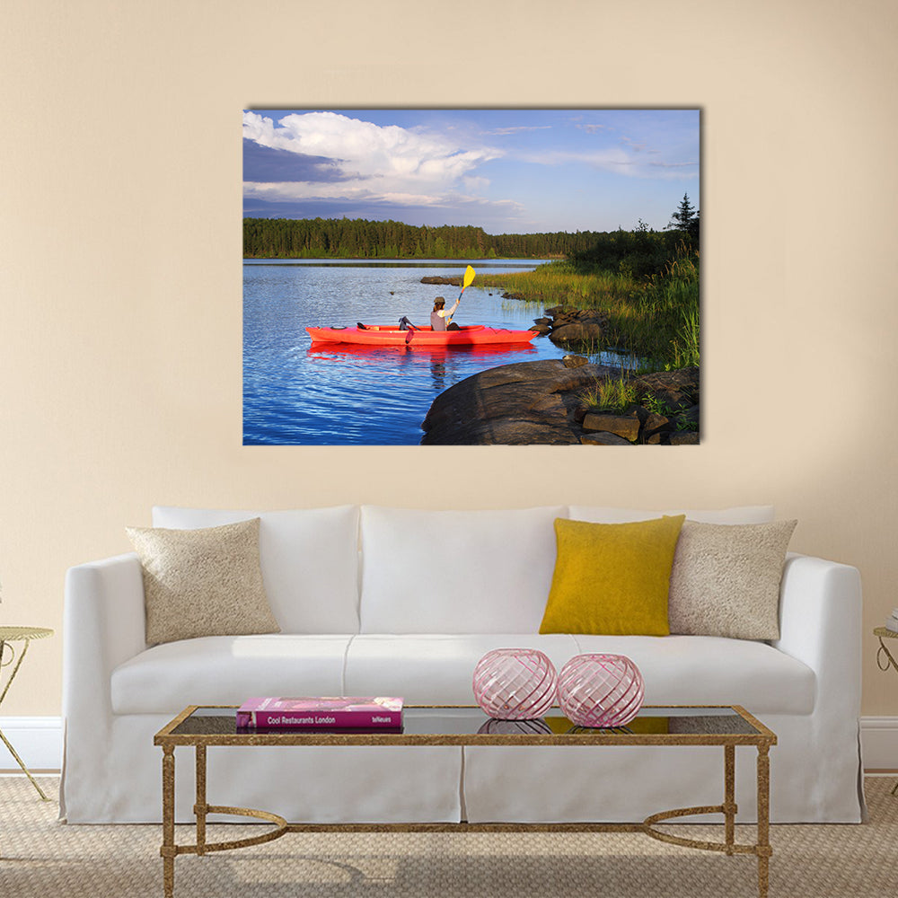 Woman canoeing in a beautiful lake at sunset Multi panel canvas wall art