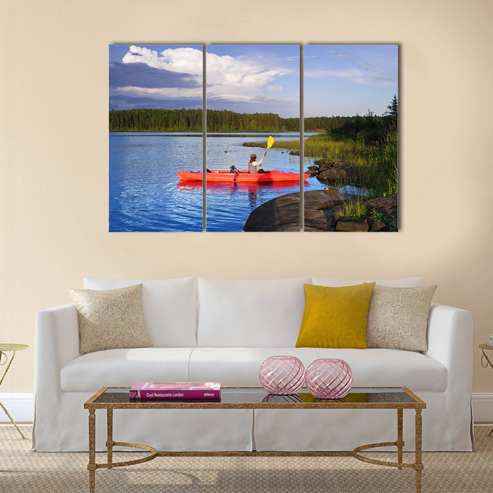 Woman canoeing in a beautiful lake at sunset Multi panel canvas wall art