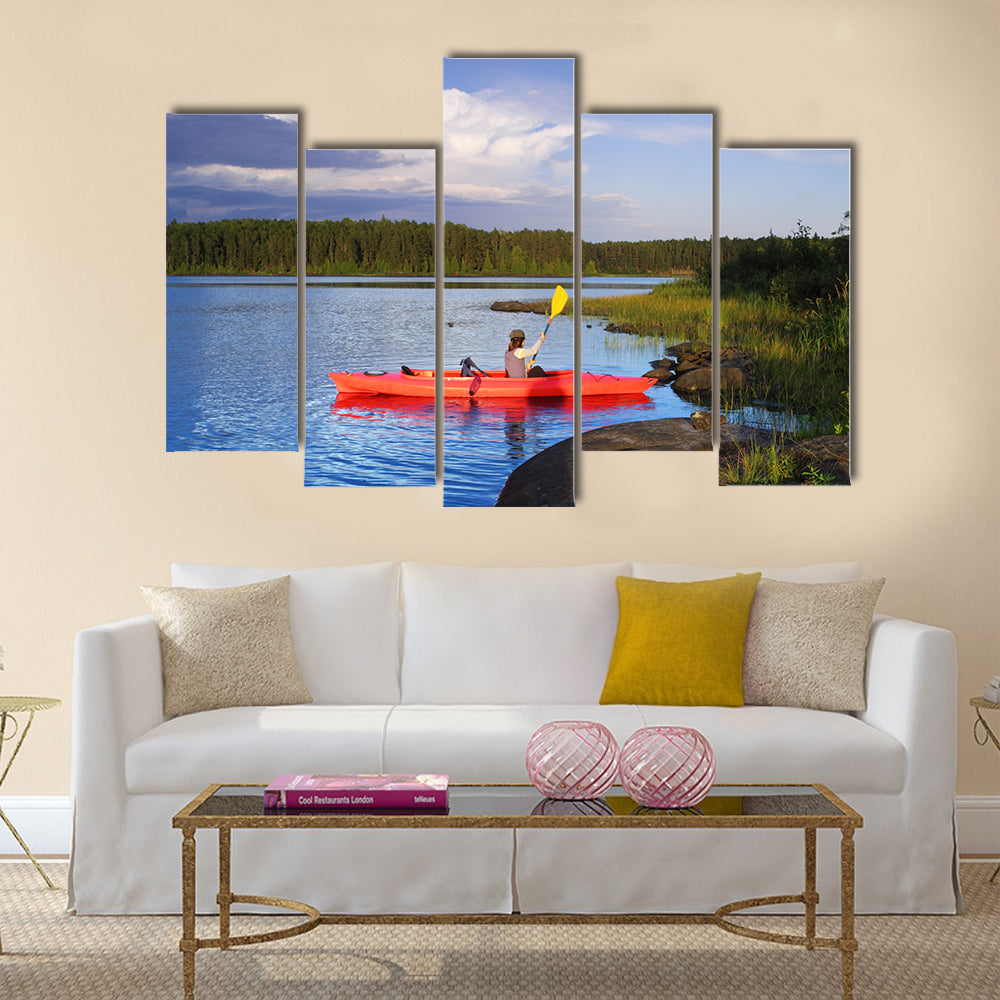 Woman canoeing in a beautiful lake at sunset Multi panel canvas wall art