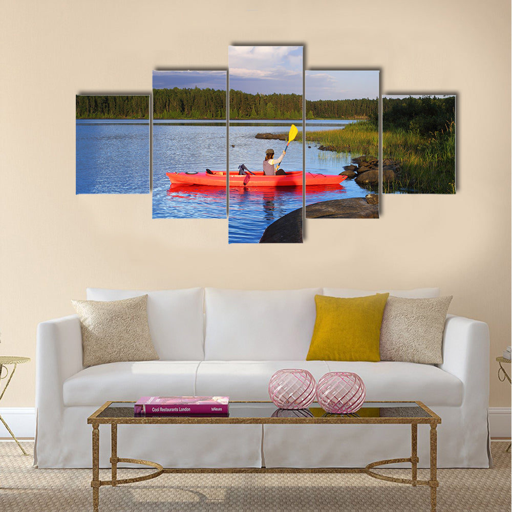 Woman canoeing in a beautiful lake at sunset Multi panel canvas wall art