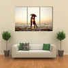 Couple kissing under umbrella at the beach in sunset multi panel canvas wall art