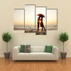 Couple kissing under umbrella at the beach in sunset multi panel canvas wall art