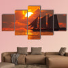 A boat sailing in front of a beautiful sunset in Key West, Florida multi panel canvas wall art