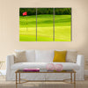 Golf ball on green near to the hole with red flag Multi Panel Canvas Wall Art