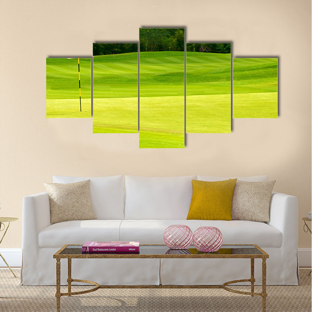 Golf ball on green near to the hole with red flag Multi Panel Canvas Wall Art