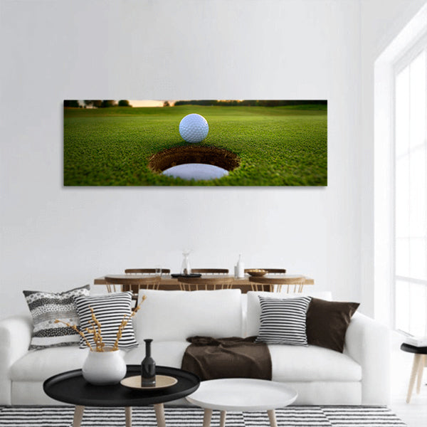 Golf ball about to fall into the cup at sunset panoramic canvas wall art