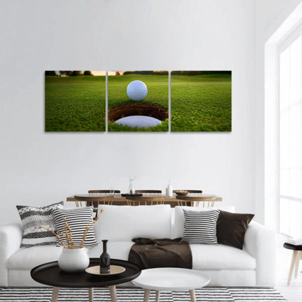 Golf ball about to fall into the cup at sunset panoramic canvas wall art