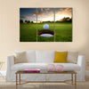 Golf ball about to fall into the cup at sunset Multi Panel Canvas Wall Art