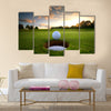 Golf ball about to fall into the cup at sunset Multi Panel Canvas Wall Art