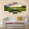 Golf ball about to fall into the cup at sunset Multi Panel Canvas Wall Art