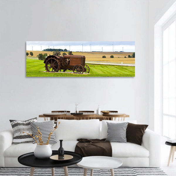 Old rusty tractor with wind turbines in the background panoramic canvas wall art