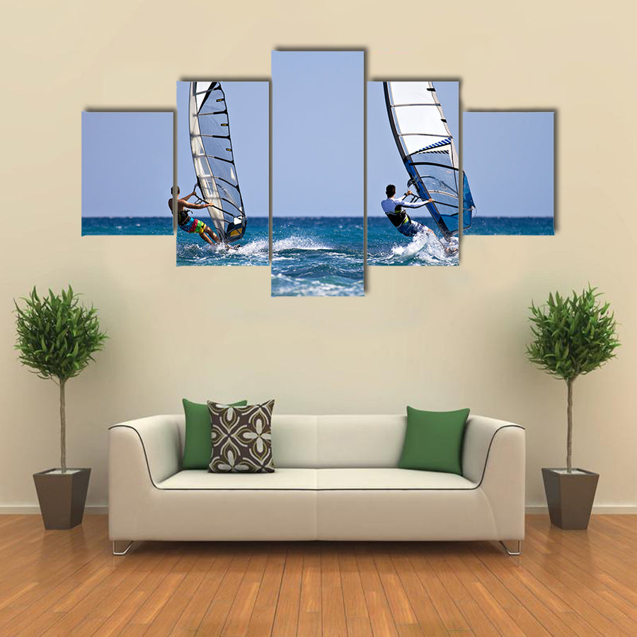 Back view of two windsurfers in action moving parallel to eath other Multi panel canvas wall art