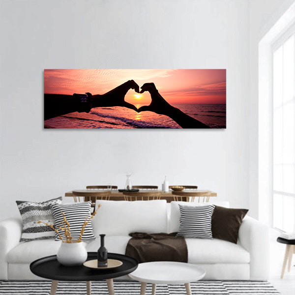 Silhouette hand in heart shape with sunrise and beach panoramic canvas wall art