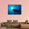 Silhouette of diver with sun disk behind Multi panel canvas wall art