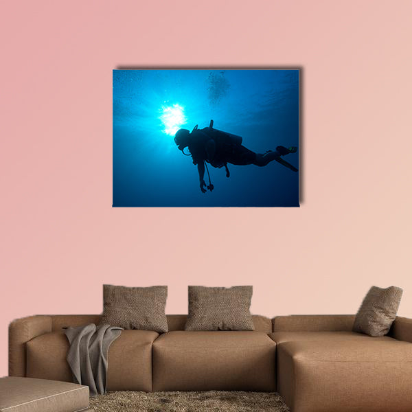 Silhouette of diver with sun disk behind Multi panel canvas wall art