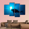 Silhouette of diver with sun disk behind Multi panel canvas wall art