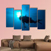 Silhouette of diver with sun disk behind Multi panel canvas wall art