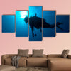 Silhouette of diver with sun disk behind Multi panel canvas wall art