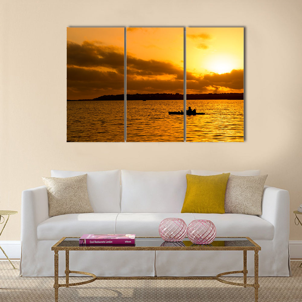 Fisherman silhouette in kayak Multi panel canvas wall art
