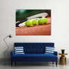 Close up view of tennis racket and balls on the clay tennis court Multi panel canvas wall art