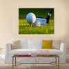 Golf ball on tee in front of driver on a gold course Multi Panel Canvas Wall Art