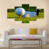 Golf ball on tee in front of driver on a gold course Multi Panel Canvas Wall Art