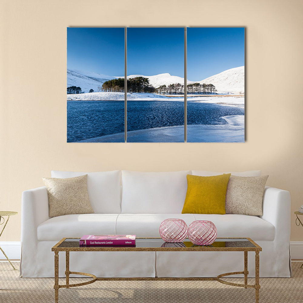 A frozen lake in a mountainous snow covered landscape multi panel canvas wall art