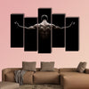 Close Up of Young Sports Man isolated on black background Multi panel canvas wall art