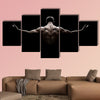 Close Up of Young Sports Man isolated on black background Multi panel canvas wall art